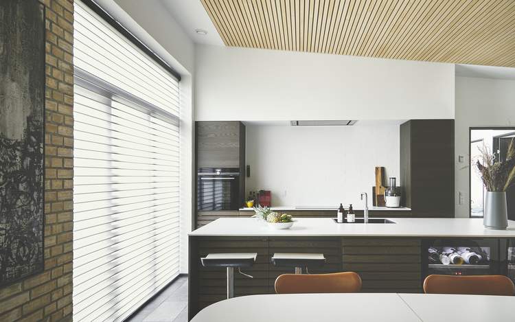 Automatiseret Silhouette® gardin i køkkenets panoramavindue hjemme hos Charlotte.
